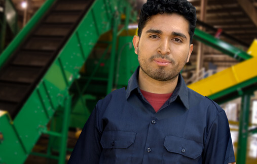 A portrait of an LTR employee standing in front of green machinery