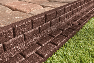 Rubber borders separating a concrete path from grass 