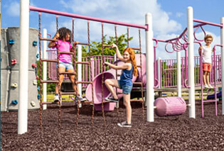 Girls playing on a pink playground on rubber mulch