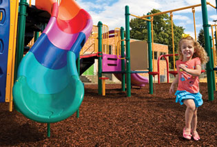 Children enjoying a tire swing on recycled nugget mulch