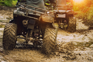 ATVs driving through mud