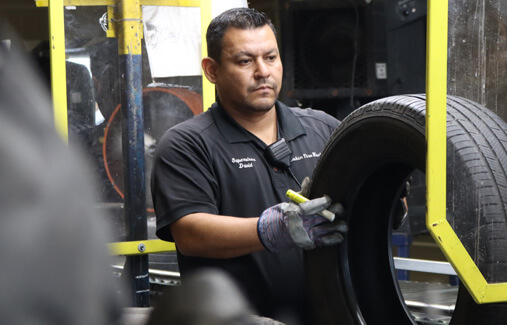 An LTR employee inspecting a used tire