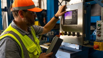 An LTR employee checking a tire processing machine