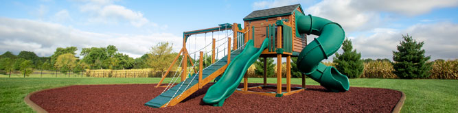 A backyard playground surrounded by rubber mulch